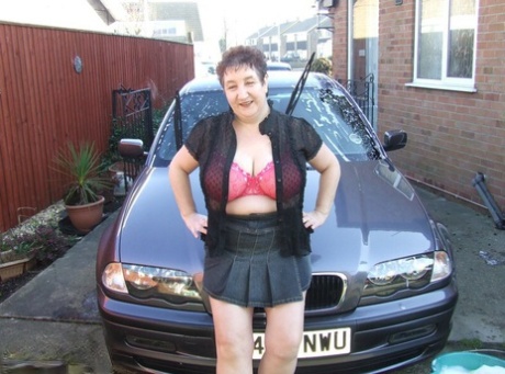 Fat old lady Kinky Carol bares her big tits while soaping up during a car wash