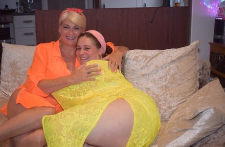 Mature lesbians strip each other naked in heels on a couch
