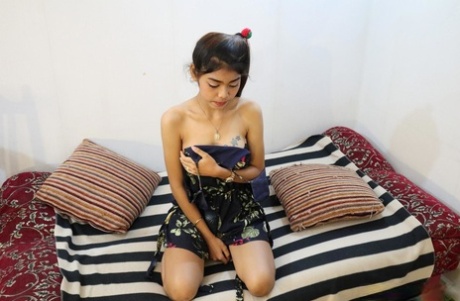 Tattooed Asian babe shows her small tits & her tight ass while naked
